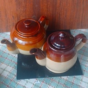 Ceramic tea kettles one with tea filter.